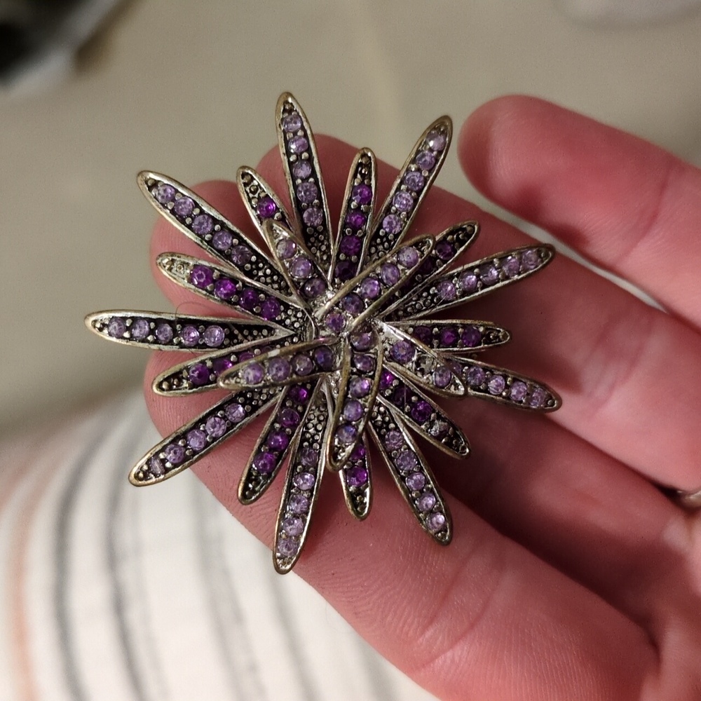 Vintage silver starburst brooch with lavender rhinestones.